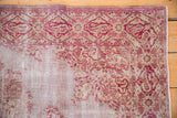 The distressed texture of a Sivas rug showing its white foundation and cranberry red patterns.