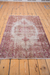 The overall design of a distressed Turkish Sivas rug in soft cranberry, grey, and white.