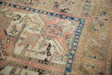 Vintage Kars carpet, angled close-up showing dusty blush field, serrated leaves, indigo border.