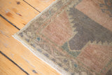 Fringe and hook design border on a vintage Oushak rug in muted peach and faded teal.