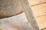 Detail of vintage Oushak rug's low pile, faded lattice, and hand knotted back.