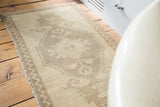 Beige field and minor zigzag border with soft pile on a vintage Oushak rug.