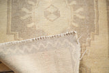 Detail of the soft, short beige pile and hand-knotted foundation of the vintage Oushak rug.