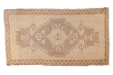 Vintage Oushak rug, beige field, prominent stepped medallion with rams horn design, 1'10