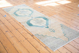 Stepped mallard green geometric border and natural abrashes on a vintage Oushak runner end.