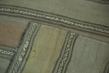 Close-up of hand-woven Kilim runner's geometric serpent channels and beige, gold stripes.