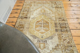 Distressed Oushak rug segment, ivory and brown tree motif with geometric stepped spandrels.