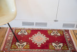 Dramatic cherry red Oushak rug, displaying central grey blush medallion and mossy bronze tree motifs.