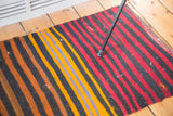 Geometric hand-woven Kilim detail featuring bold horizontal power colors.