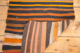 Hand woven vintage Kilim mat, horizontal dark, tangerine stripes, revealing its vertically striped reverse.