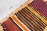 Vintage hand woven Kilim mat in bold red, navy, tangerine, and saffron stripes.