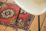 Vintage Oushak rug mat corner with cinnabar red field, geometric border, and fringed edge.
