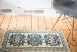Vintage Oushak rug with geometric navy, brown, teal medallions and leaf border.