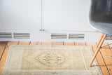 Vintage Oushak rug featuring celadon, charcoal, and peach geometric medallion pattern.