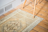 Vintage Oushak rug's elongated celadon green and silver charcoal medallion on golden peach.