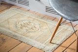 Woven texture and aged fringe on the light golden peach Oushak rug mat.