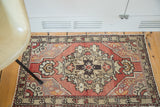 Vintage Oushak rug with ornate charcoal, silver, beige medallion on a cinnabar red field.