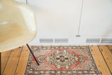 Vintage hand knotted Turkish Oushak rug, cinnabar red field with ornate medallion and meandering leaf border.