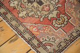 Vintage Oushak rug corner with cinnabar red field, beige spandrels, and leaf border.