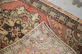 Vintage Oushak rug corner displaying hand-knotted back and cinnabar field.