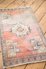 Distressed Oushak rug corner detail, faded orange and dusty rose with geometric border.