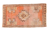 Distressed hand knotted Oushak rug, faded orange field, grey medallion, and stylized tree motifs.