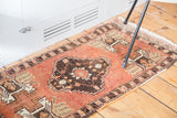 Softened cinnabar red Oushak field with geometric tree and planter motifs.