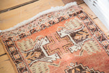 Vintage Oushak rug close-up of hand-knotted fringe and rectilinear stepped pattern with cinnabar, brown, beige.