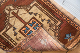 Vintage Oushak rug corner revealing tribal copper, aqua design and hand-knotted foundation.