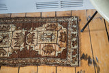 Hand-knotted vintage Oushak rug corner showing geometric patterns and soft wooded tones.