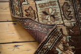 Curled corner of vintage Turkish Oushak rug showing hand-knotted back and warm brown patterned pile.