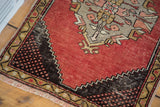 Storied distress on dark checkered spandrel and meandering leaf border of vintage Oushak rug.
