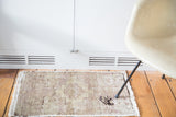 Distressed Oushak mat with low pile, hint of mauve, and faded planter design.