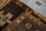 Hand-knotted texture, fringe, and star motifs on a folded vintage Oushak rug corner.