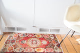 Vintage hand knotted Oushak mat, softened cherry red field, octagonal star medallion and geometric border.