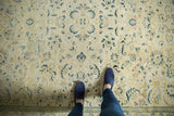Distressed Sivas carpet section featuring faded saffron, celadon, and bronze floral design with border.