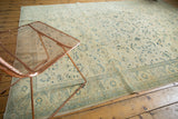 Distressed Sivas carpet detail with faded saffron field, hand-knotted celadon and bronze floral patterns.