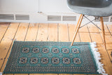 Forest green vintage Bokhara rug, featuring double column guls with ivory, beige, navy details.