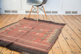 Vintage Jijim rug featuring horizontal geometric stripes in madder root red and charcoal.