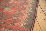 Bound edge with madder root red and charcoal geometric diamond panels of a Turkish Jijim rug.