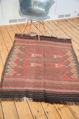 Jijim rug section: madder root red field, dark borders, geometric channel and plant motifs.