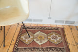 Vintage Kilim mat detail: stepped saffron medallion on a coffee field, wave border.