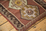 Vintage Kilim rug corner with fringed edge and reciprocating wave border design.