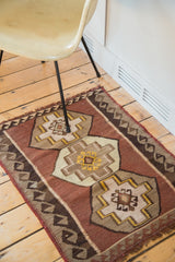 Vintage kilim rug detail showing dark brown reciprocating wave border and saffron.