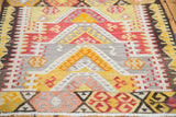Vibrant stepped medallions with hook designs and crab motifs on a Kilim rug.