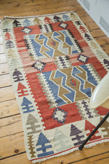 Vintage Turkish Kilim rug corner, geometric arrow border, diamond patterns, red, blue, ivory.