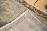 Folded vintage Oushak rug corner revealing distressed celadon pile and hand-knotted foundation.