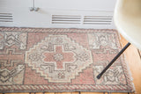 Stepped grey diamond motif on blush field with barber pole border on this Oushak rug.