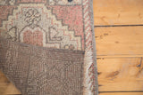 Vintage Oushak rug corner showing hand-knotted foundation, blush, grey pile, and fringe.