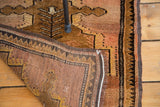 Vintage Turkish Oushak rug corner, showing abrash, dark geometric border, and woven back.
